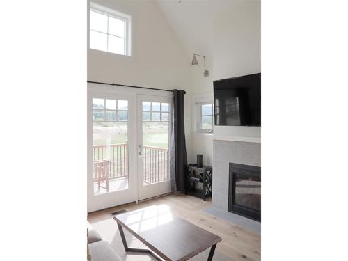 a living room with a fireplace and a tv at Owl's Nest Resort in Thornton