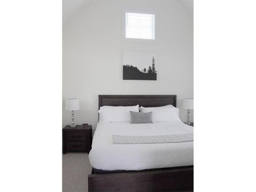 a bedroom with a bed with a black and white picture at Owl's Nest Resort in Thornton