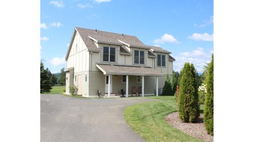 a large white house with a driveway at Owl's Nest Resort in Thornton