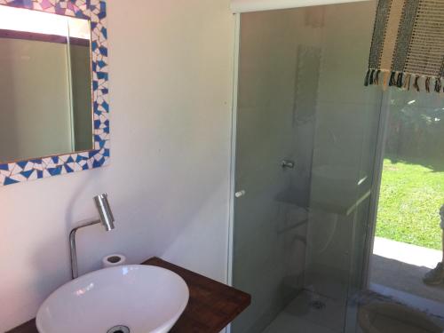 a bathroom with a sink and a glass shower at Privacidade e Conforto no Saco da Capela in Ilhabela