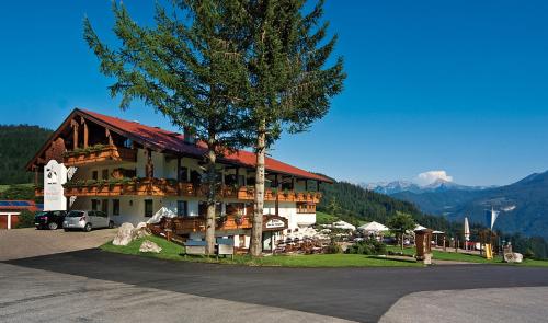 a large building with a tree in front of it at Hotel-Gasthof Nutzkaser in Ramsau