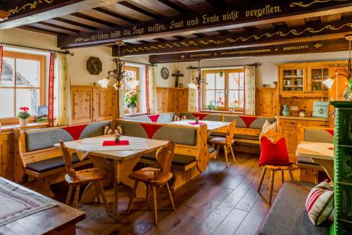 a restaurant with wooden tables and chairs and windows at Linharterhof in Haus im Ennstal