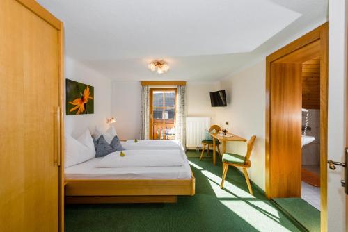 ハウス・イム・エンスタールにあるLinharterhofのベッドとデスクが備わるホテルルームです。