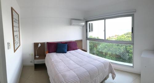 1 dormitorio con cama y ventana grande en Luz de Jacinta en Colonia del Sacramento