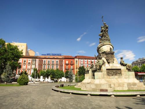 a statue in a square in front of a building at Hotel Colón Plaza in Valladolid