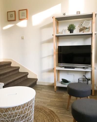 - un salon avec une télévision à écran plat et des escaliers dans l'établissement Beau Site, à Villard-de-Lans