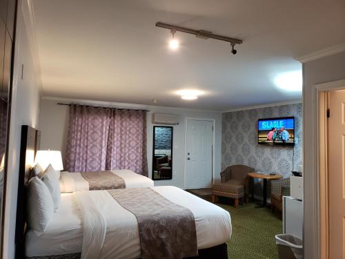 a hotel room with two beds and a flat screen tv at Regency Inn & Suites in Cornwall