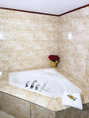 a bath tub in a tiled bathroom at Regency Inn & Suites in Cornwall