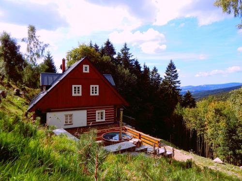 a red house on the side of a hill at Kajzrovka in Rokytnice nad Jizerou