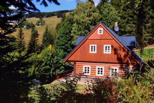 an orange house in the middle of a forest at Kajzrovka in Rokytnice nad Jizerou