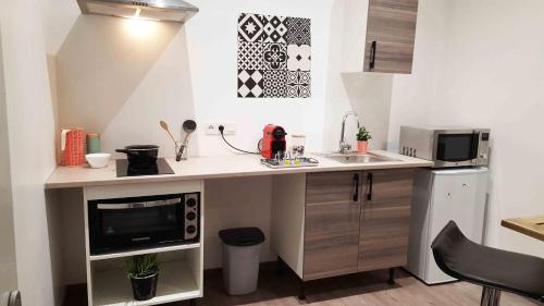 a small kitchen with a sink and a microwave at Appart Confortable à Tulle - Bien situé - Calme in Tulle