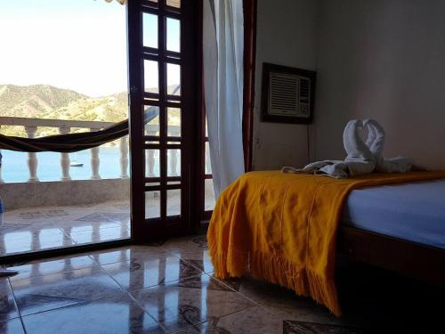 a bedroom with a bed with an open door to a balcony at Hospedaje El Shadday in Taganga