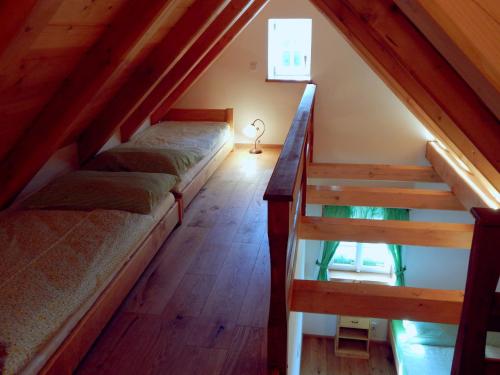 a attic room with two beds and a staircase at Kajzrovka in Rokytnice nad Jizerou