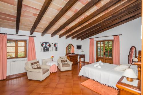 a large bedroom with a bed and two chairs at Villa El Olivo in Pollença