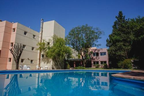 a swimming pool in front of a building at Convivir Departamentos in Córdoba