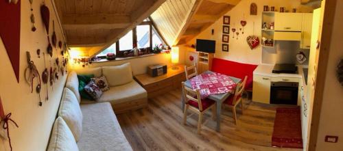 a small living room with a table and a kitchen at Casa Margherita in Tarvisio
