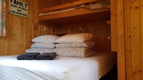 a stack of towels on a bed in a cabin at Cozy Cabin in the Woods in Selfoss