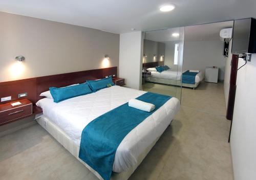 a bedroom with a large bed and a mirror at Sunec Hotel in Chiclayo
