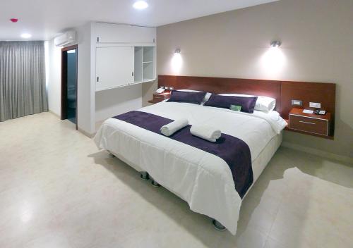 a bedroom with a large bed with two pillows at Sunec Hotel in Chiclayo