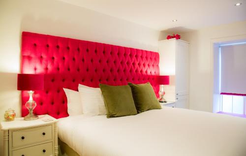 a bedroom with a large white bed with a red headboard at Winckley Stays in Preston