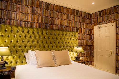 a bedroom with a bed and a large wall of books at Winckley Stays in Preston