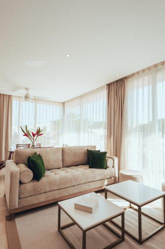 a living room with a couch with green pillows at Antera Hotel & Residences in Playa del Carmen
