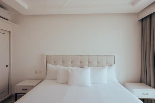 a bedroom with a large white bed with white pillows at Antera Hotel & Residences in Playa del Carmen