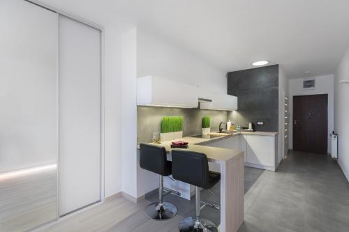 a kitchen with a table and chairs in a room at LAJŚNIJ sobie Apartment in Poznań