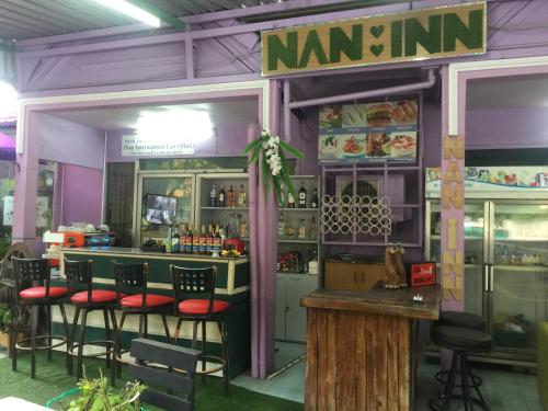 a restaurant with a bar with stools in front of it at Nan Inn Bungalow in Karon Beach