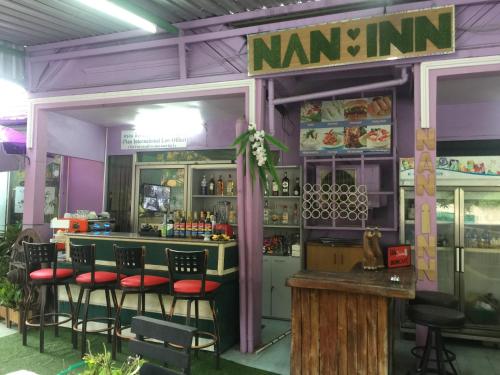 a restaurant with a bar with stools in front of it at Nan Inn Bungalow in Karon Beach