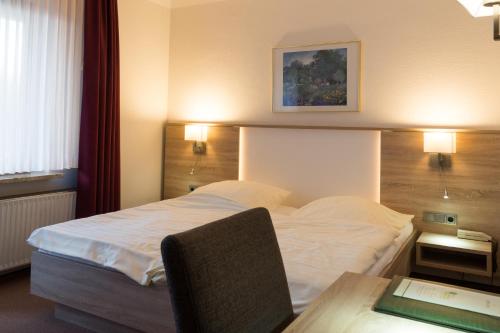 a hotel room with a bed and a desk with a table at Hotel Gammelby in Eckernförde