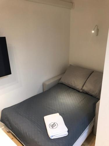 Ce lit se trouve dans une petite chambre dotée d'un oreiller blanc. dans l'établissement FIFNY Apartment, à Poznań