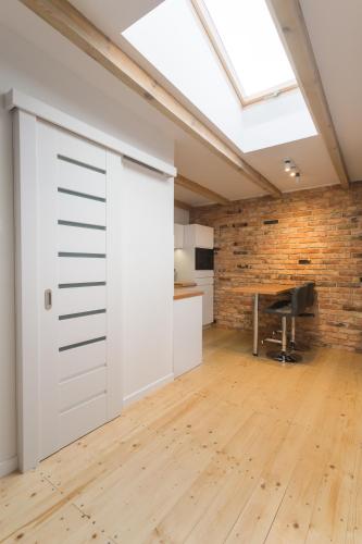 una porta aperta del garage in una stanza con muro di mattoni di FIFNY Apartment a Poznań