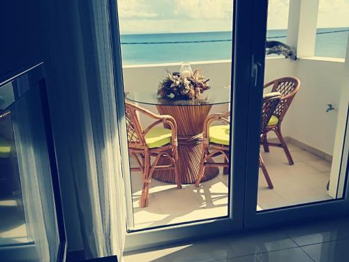 a table and chairs on a balcony with a view of the ocean at Goldfish Seaside Luxury Houses in Kómi