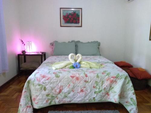 a bedroom with a bed with a bow on it at Suites do Reino Penedo RJ in Penedo