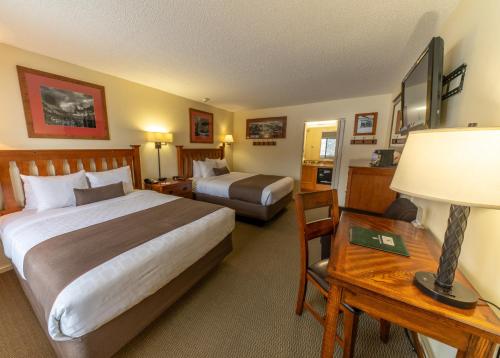 a hotel room with two beds and a table with a lamp at Pokolodi Lodge in Snowmass Village