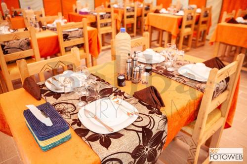 a dining room with a table with plates and napkins at Sahara Happy Camp in Merzouga