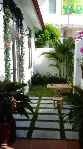 a patio with a bench in front of a house at Mekong Palm House in Can Tho