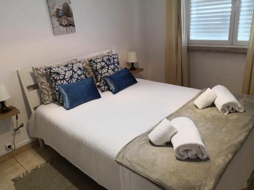 a bedroom with a large white bed with blue pillows at Graça Lovers 2 in Lisbon