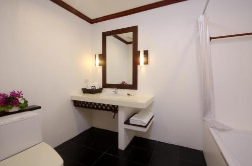 a bathroom with a sink and a mirror at The Front Village - SHA Plus in Karon Beach