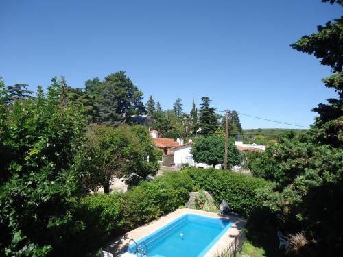 einen Pool in einem Garten mit Bäumen in der Unterkunft Hosteria Zure-Echea in Valle Hermoso