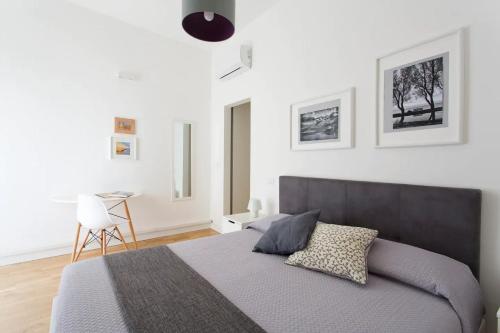 a bedroom with a large bed and a desk at BB4U Apartments in Palermo