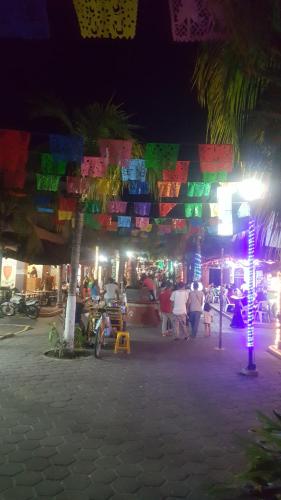 a group of people walking around a market at night at Casa Arcoiris Zihuatanejo B&B in Zihuatanejo