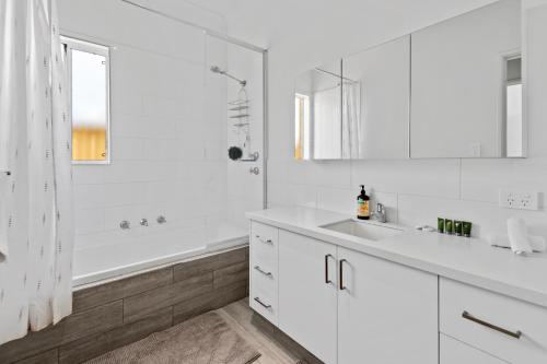 a white bathroom with a tub and a sink at Vasse Manor in Vasse