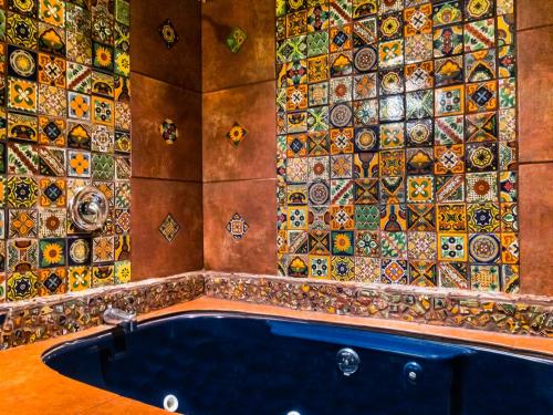 a bathroom with a bath tub with a mosaic wall at Talus Rock Retreat in Sandpoint