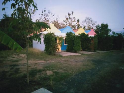 a house with colorful roofs in a yard at เซราะกราว บูติก รีสอร์ท Sohground Boutique Resort in Prakhon Chai