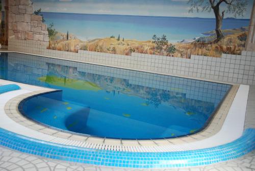 a large swimming pool with a painting on the wall at Apart Ideal in Lermoos