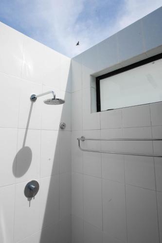 a white bathroom with a shower with a mirror at Dreamview Villas in Rakiraki