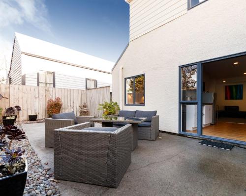 a patio with wicker chairs and a table at Drovers Motor Inn in Palmerston North