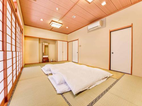 A bed or beds in a room at Sagayamato Onsen Hotel Amandi